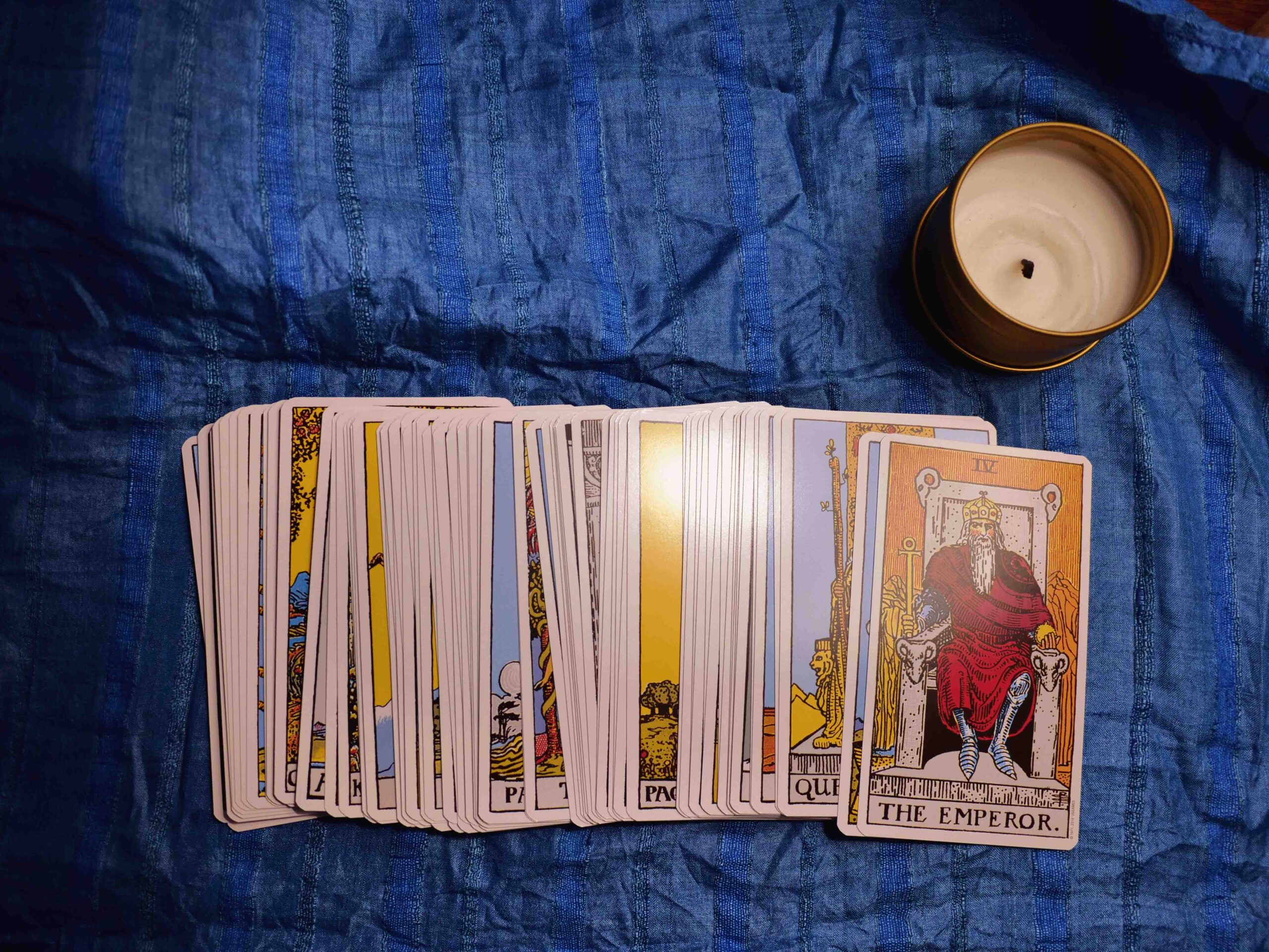 A splay of tarot cards, showing the Emperor on top.